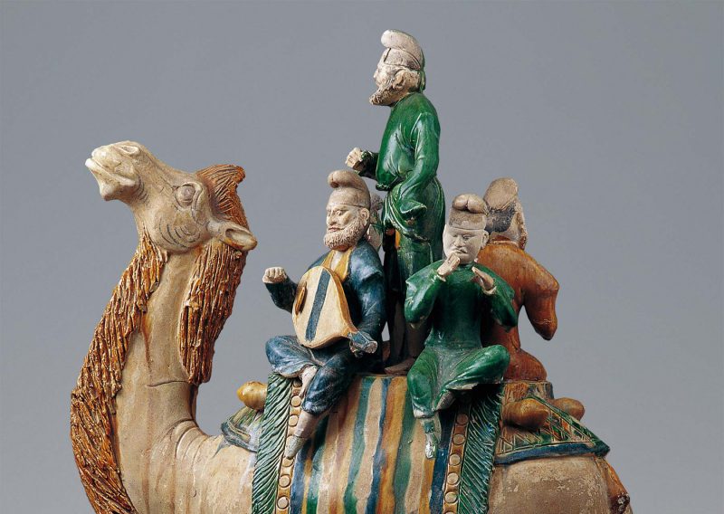 Four musicans on a camel