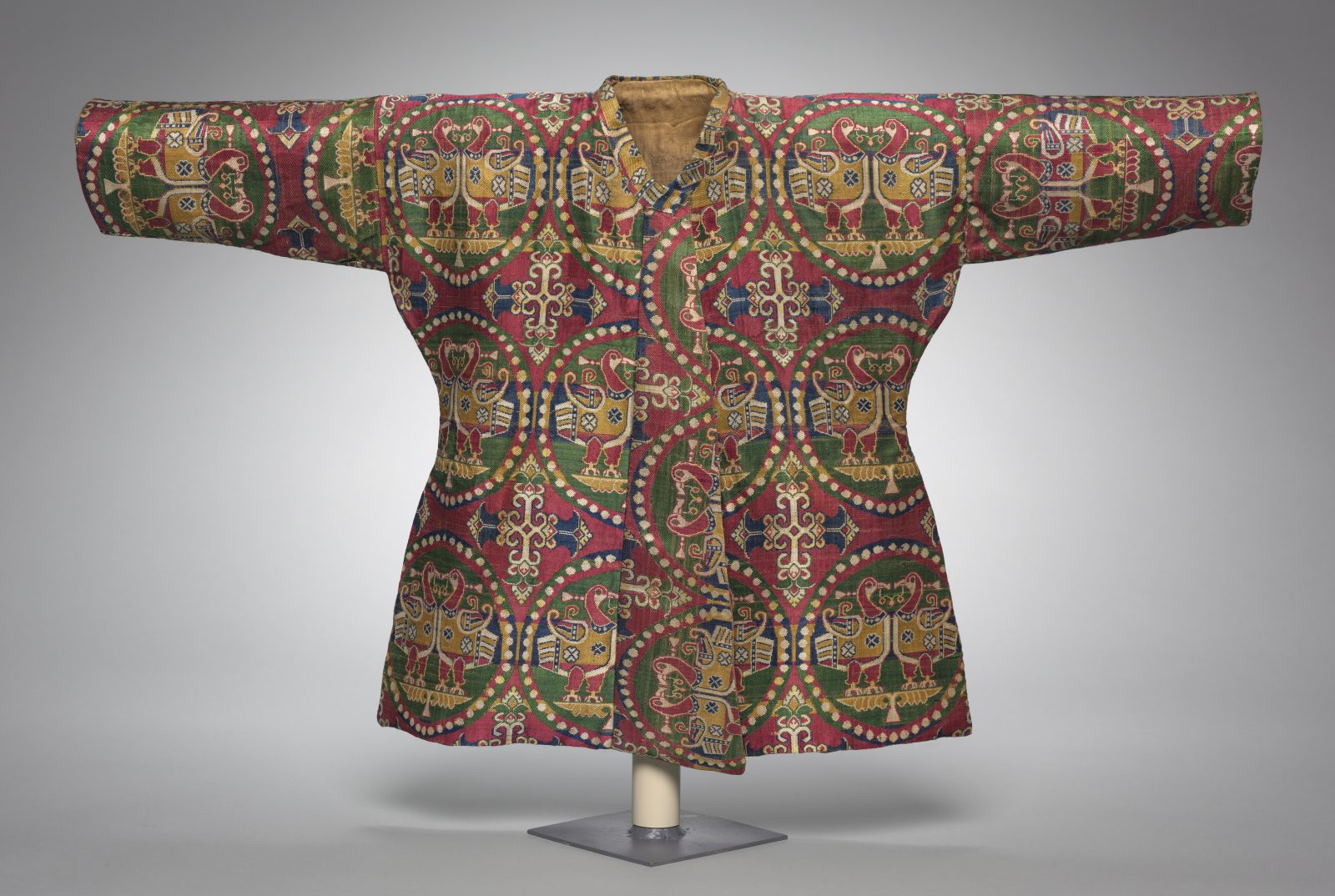 Child’s Coat with Ducks in Pearl Medallions. Uzbekistan (probably Sogdia), 700s. Silk: weft-faced compound twill weave (samite). Width across shoulders: 84.5 cm; length back of neck to hem: 51.4 cm. Silk, weft-faced compound twill weave (samite); W. 84.5 cm (across shoulders), 51.4 cm (length back of neck to hem). The Cleveland Museum of Art, Cleveland, 1996.2.1. Photograph © The Cleveland Museum of Art., Cleveland, Ohio, Purchase from the J. H. Wade Fund 1996.2.1.